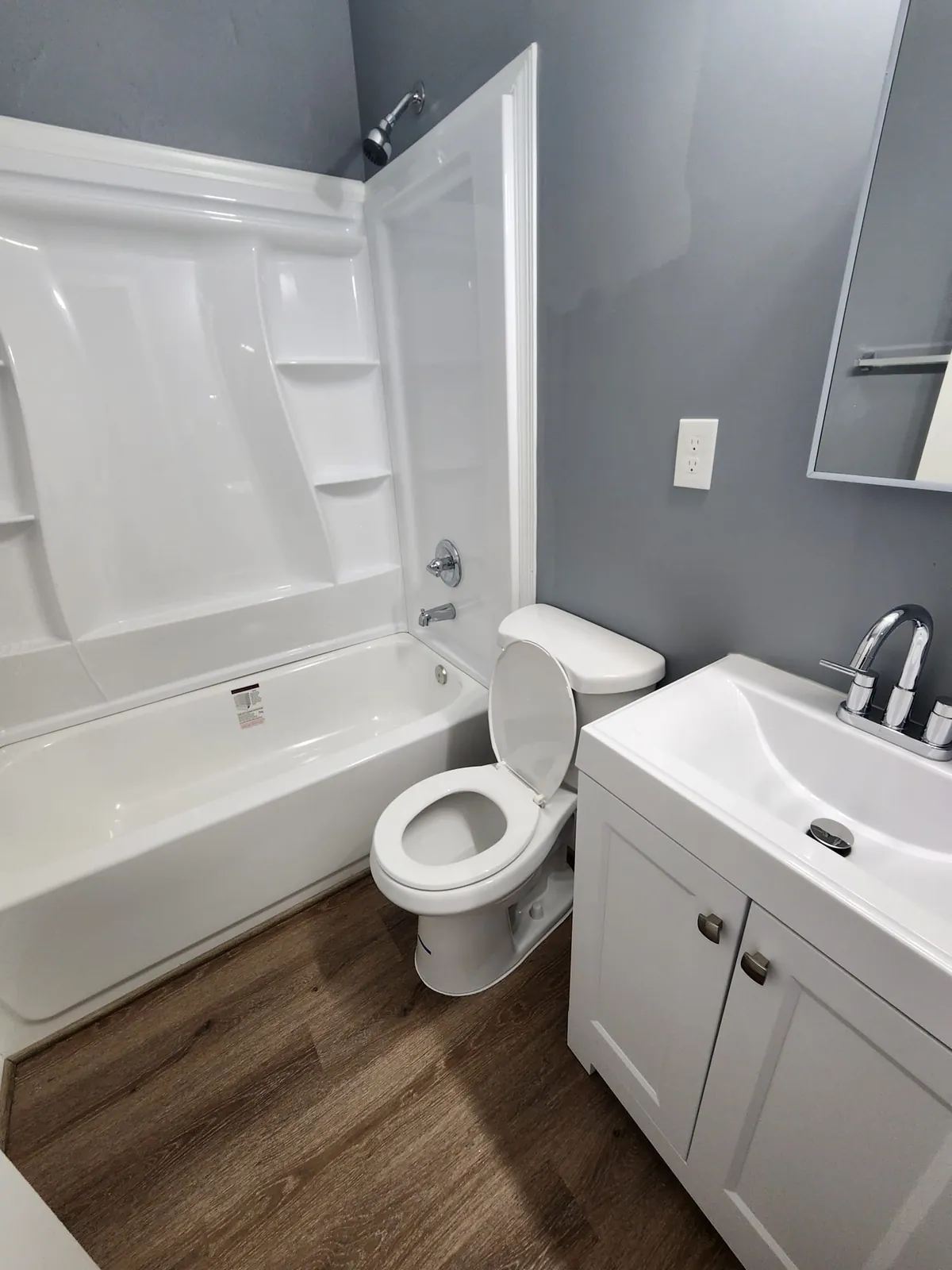 Updated bathroom with new tub surround, vanity, and flooring