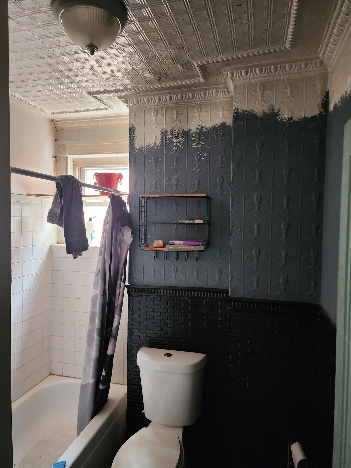 Before: dated bathroom with peeling paint over the pressed-tin walls