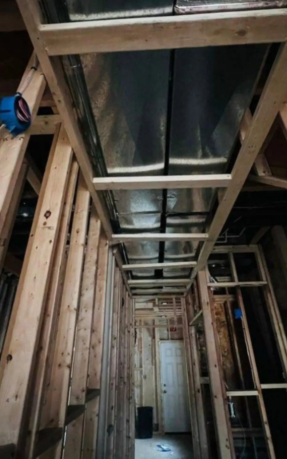 Long hallway framed in new studs with ceiling soffits built around ductwork