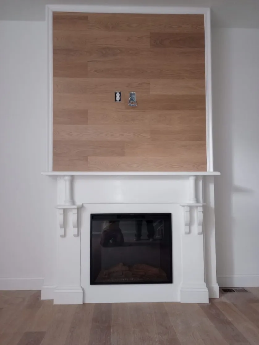 Restored fireplace mantel with electric insert and wood-plank accent wall