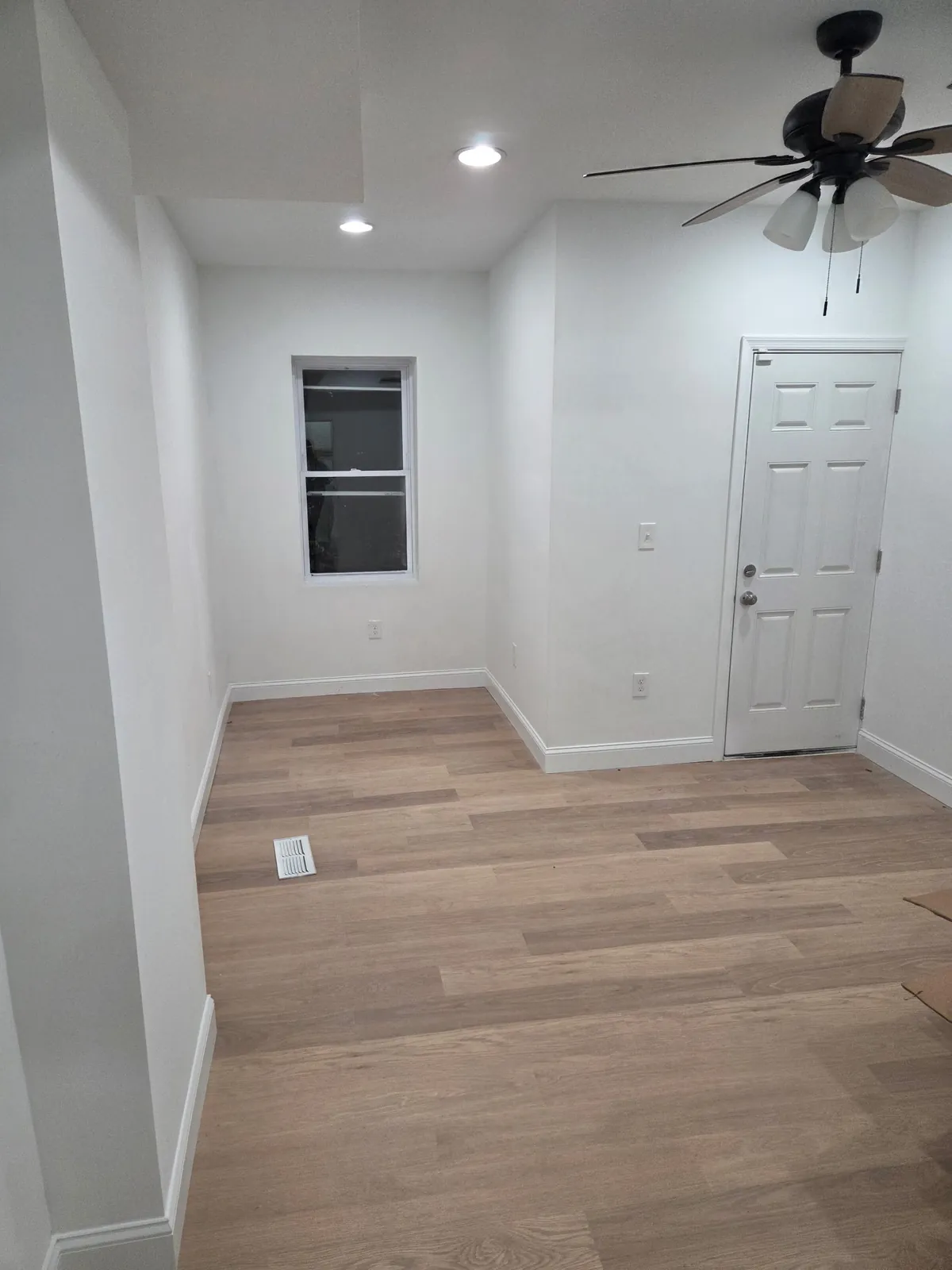 Freshly painted room with new wood-look plank flooring and recessed lighting