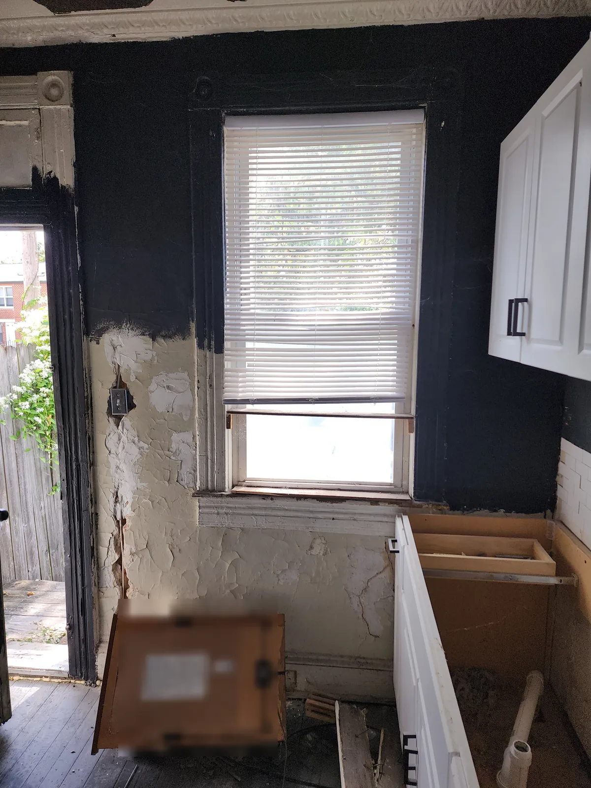Before: kitchen mid-demolition with cabinets removed and damaged wall patches