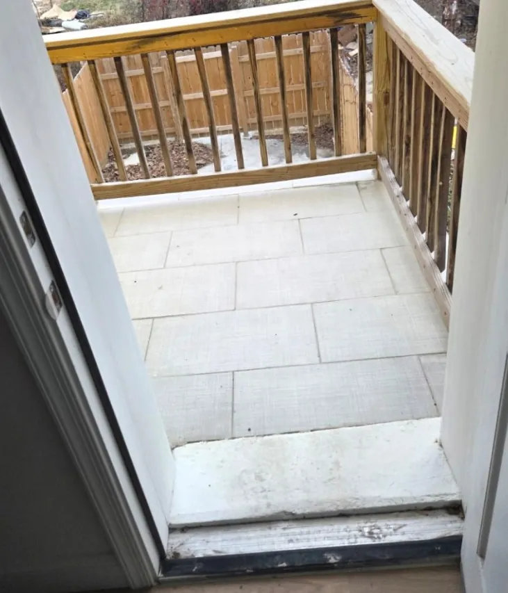 Rear balcony with new wood railings and a tiled deck surface